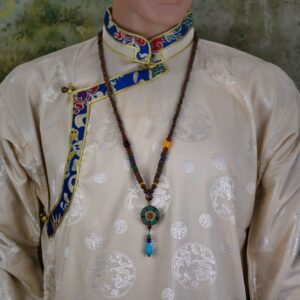Collier Om tibétain | Turquoise & bois de santal | Artisanat Népal Authentique. Découvrez ce collier Om tibétain, fait-main avec amour au Népal.