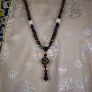 Collier bouddhiste | Nœud infini | Agate & bois de santal | Artisanat Tibétain Népalais. Adoptez un style spirituel et authentique avec ce collier bouddhiste orné du nœud infini.