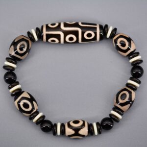 Découvrez le Bracelet Dzi Porte-bonheur de la Boutique Zen Himalayan-eshop. Un bijou spirituel tibétain unique, composé d'agate noire, d'agate blanche et d'onyx noir, conçu pour attirer la richesse, la santé, l'honneur, la longévité et le bonheur. Achetez dès maintenant votre porte-bonheur tibétain authentique !